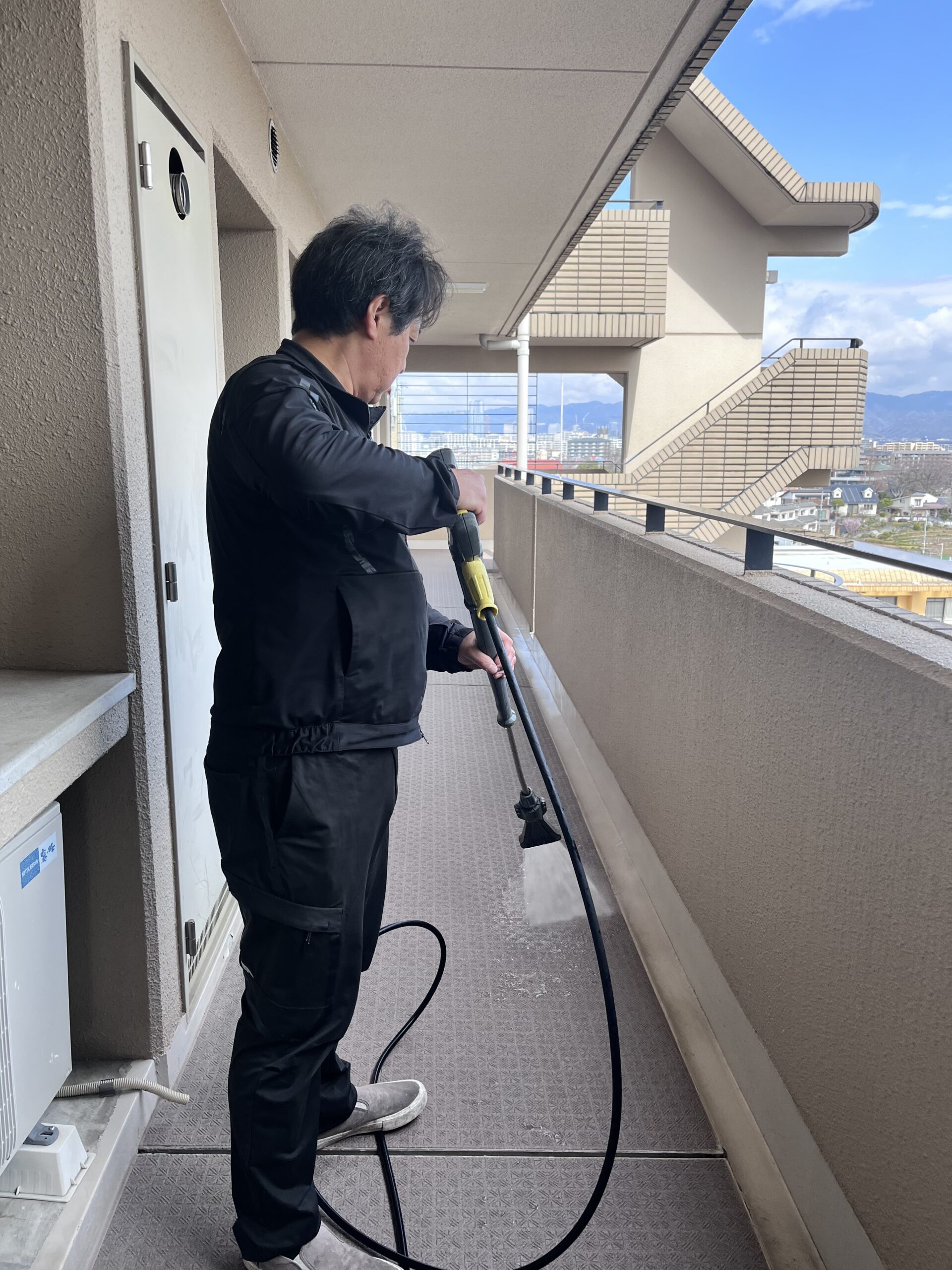 屋外の床を高圧洗浄している作業の様子
